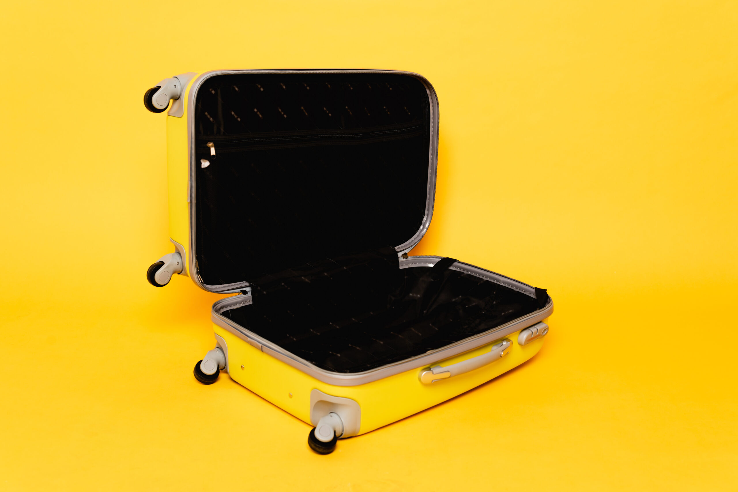 Offener, gelber Koffer. Bereit, gepackt zu werden.